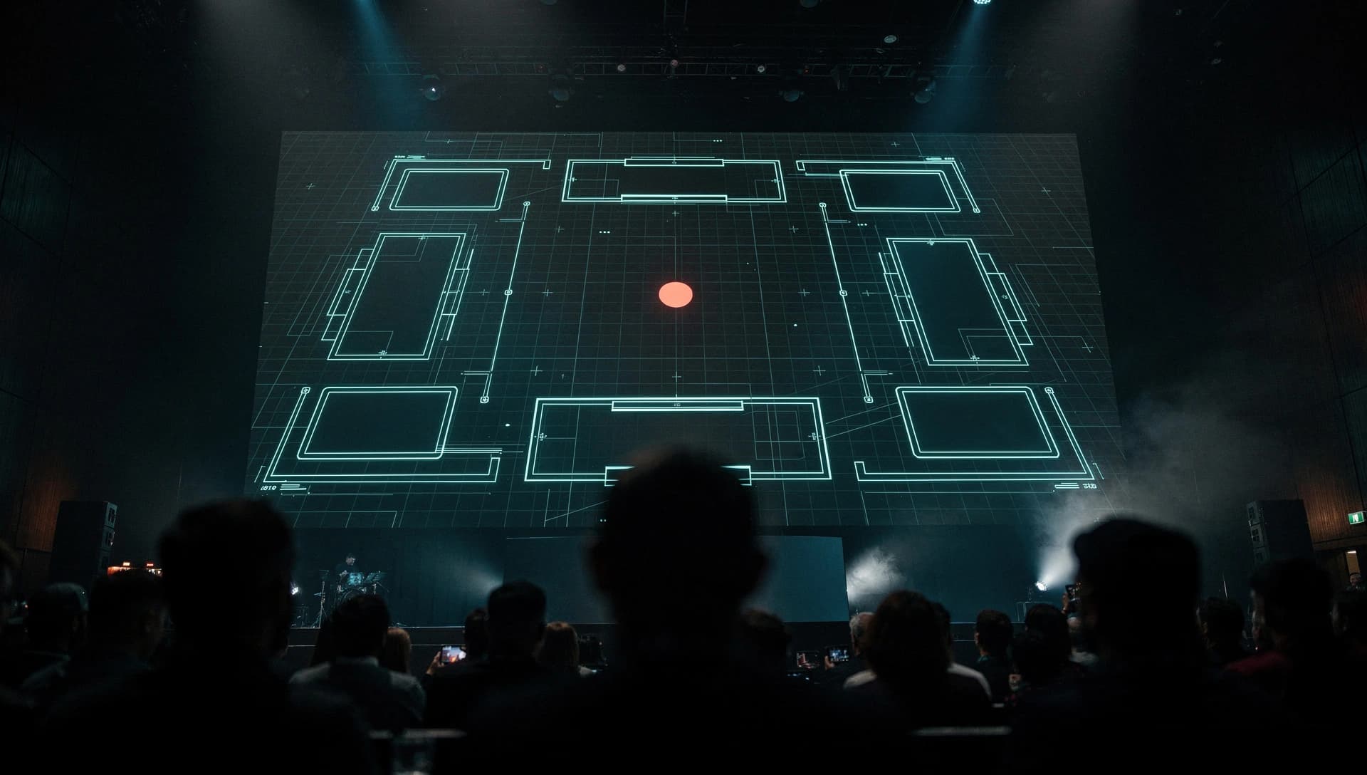 A darkened event hall seen from among silhouetted spectators, facing a large LED wall that shows a glowing cyan trading-card battlefield grid with one coral marker at its centre